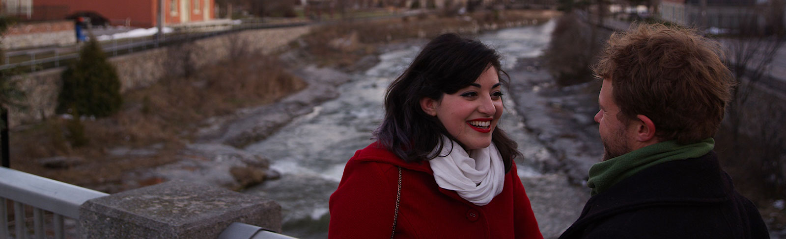 Couple on Walton Street bridge overlooking Ganaraska River in the winter in Port Hope