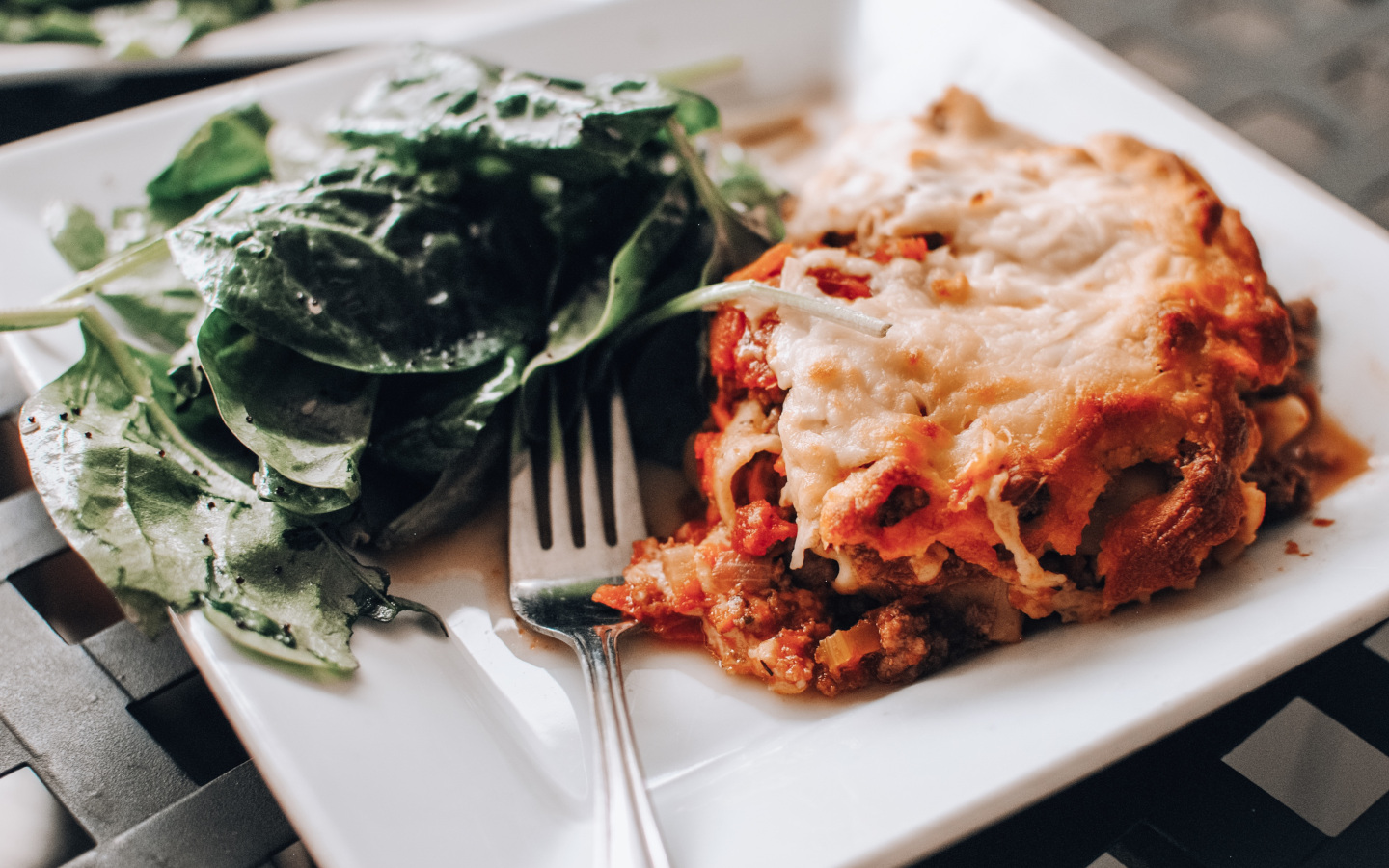 Plate of food with salad, fork and pasta