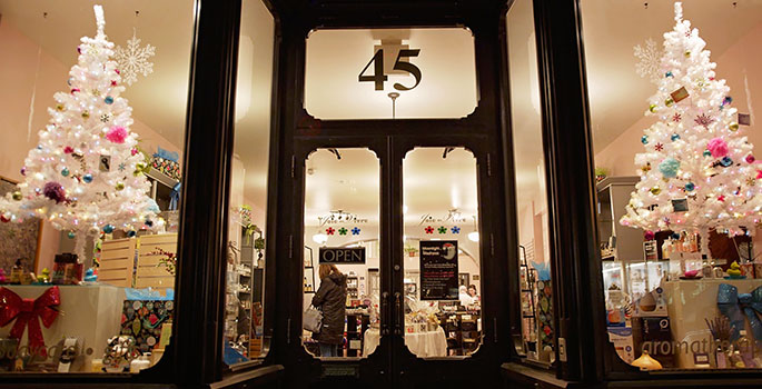 The front entrace of a store, with Christmas trees on either side