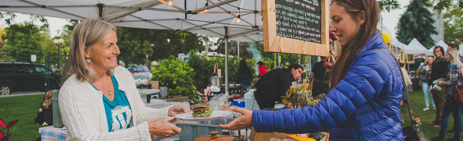 Woman serving food from the vendor market at the Cultivate Festival in Port Hope