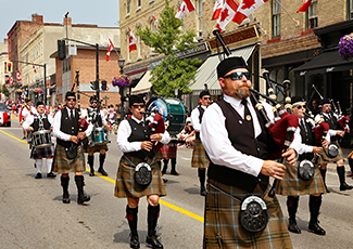 A parade of bagpipers walking down the street
