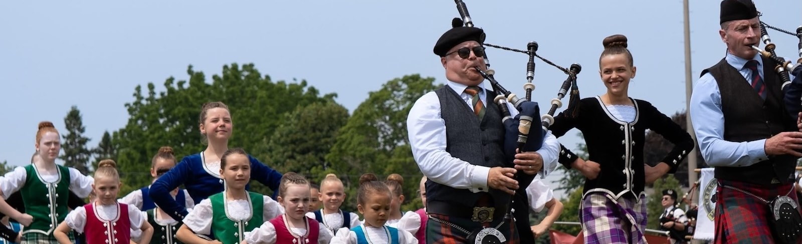 Highland dancers and pipers walk proudly across the green at the Northumberland Scottish Festival. 