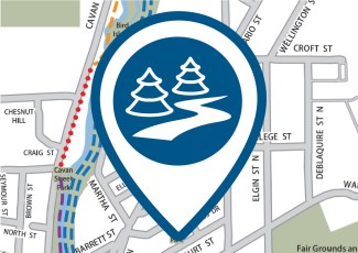 A pin icon of a path and trees in front of a digital map.
