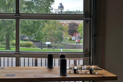 A table set with beer cans and flights in front of a large glass garage door