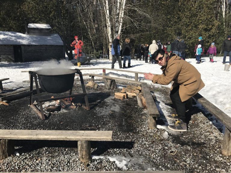 The author of this blog crouching over the smoking fire which also has a large black pot boiling.