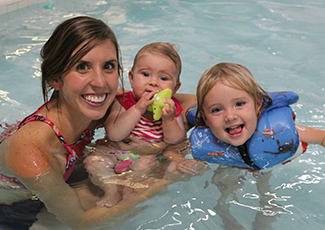 A mother with her two young children in a shallow indoor pool