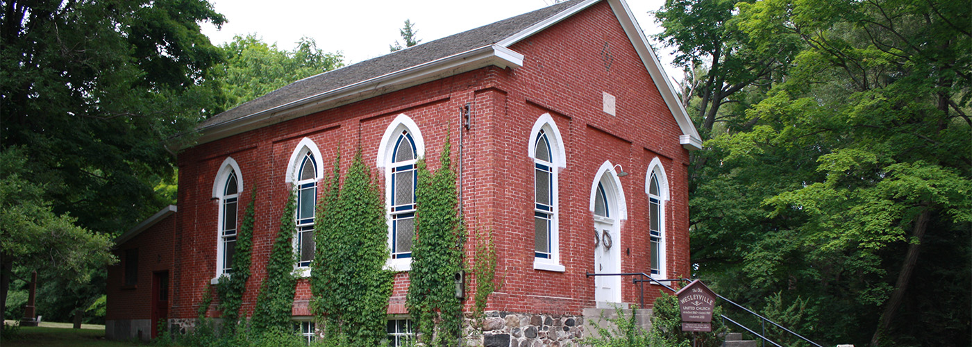 A large brick church among trees.